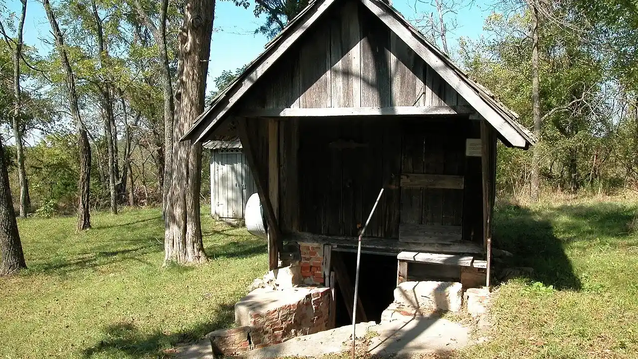 Storm cellar entrance with a wooden shelter roof