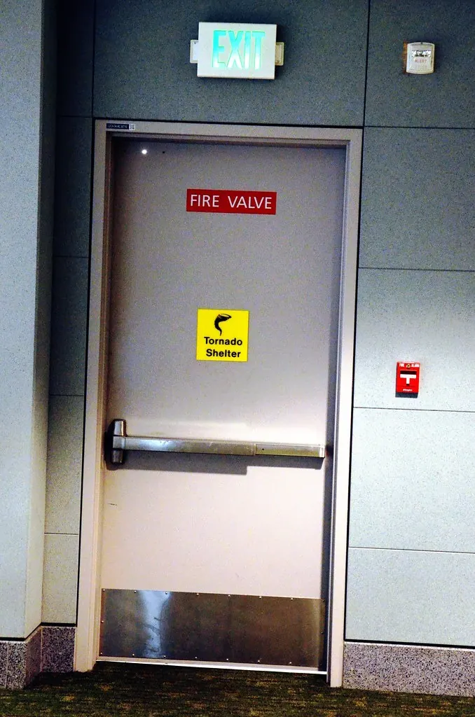 Steel tornado shelter door with exit sign