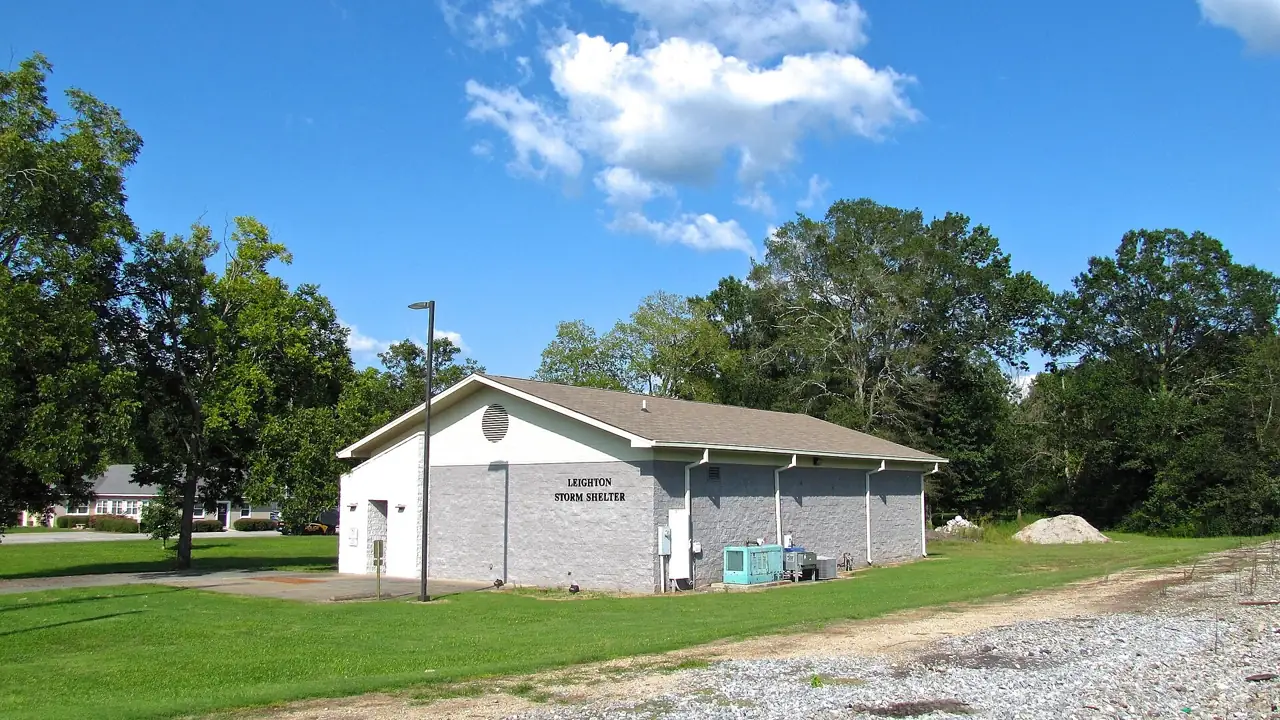 Concrete storm shelter beside a building