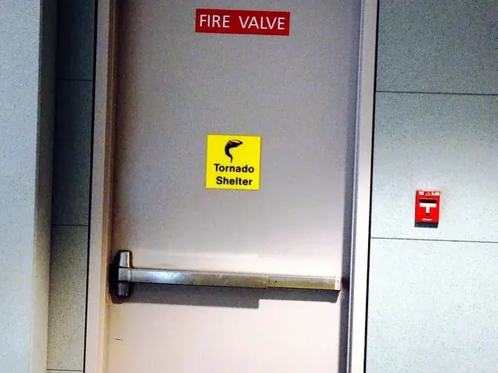 Steel tornado shelter door with exit sign
