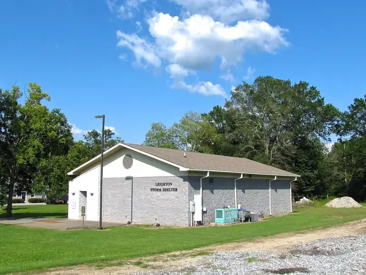 Concrete storm shelter beside a building